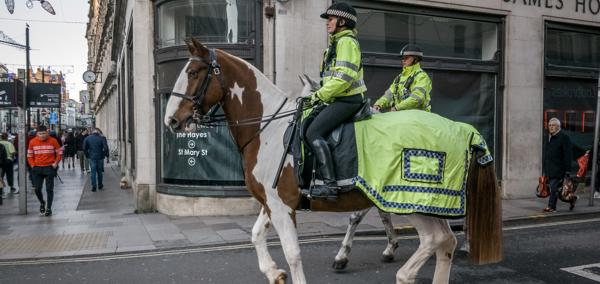 Police officers riding horses through a high street in Cardiff 