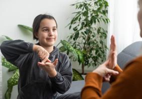 An image of a child signing with another person