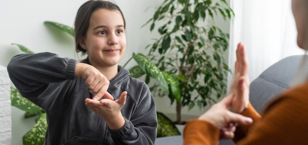 An image of a child signing with another person