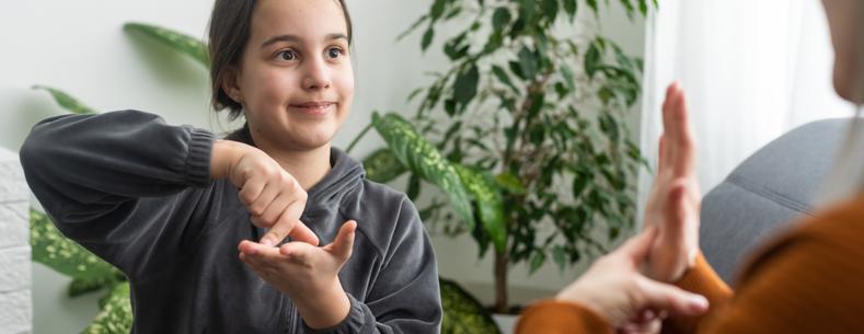 An image of a child signing with another person