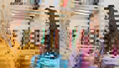 Two women sit at a table with a pot of tea, having a conversation in sign language.