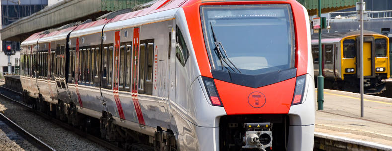 A Transport for Wales train waiting at the platform of a station.