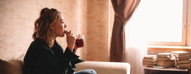Girl Sitting On A Sofa With A Hot Drink.