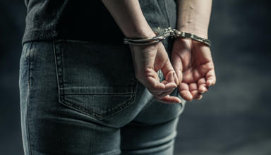 Hand behind a person’s back in Handcuffs