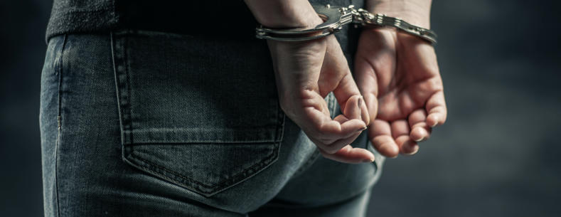 Hand behind a person’s back in Handcuffs