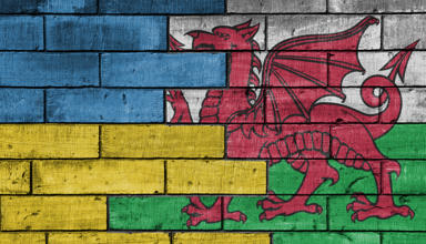 wooden blocks painted in the Welsh and Ukrainian flags meeting in the middle 