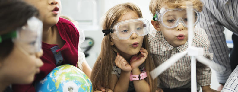 Children in a science lesson with one holding a small globe.