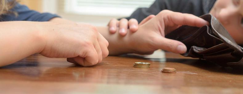 Picture of a mother with her son, counting her last coins from her purse.