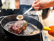 Steak being cooked in a pan