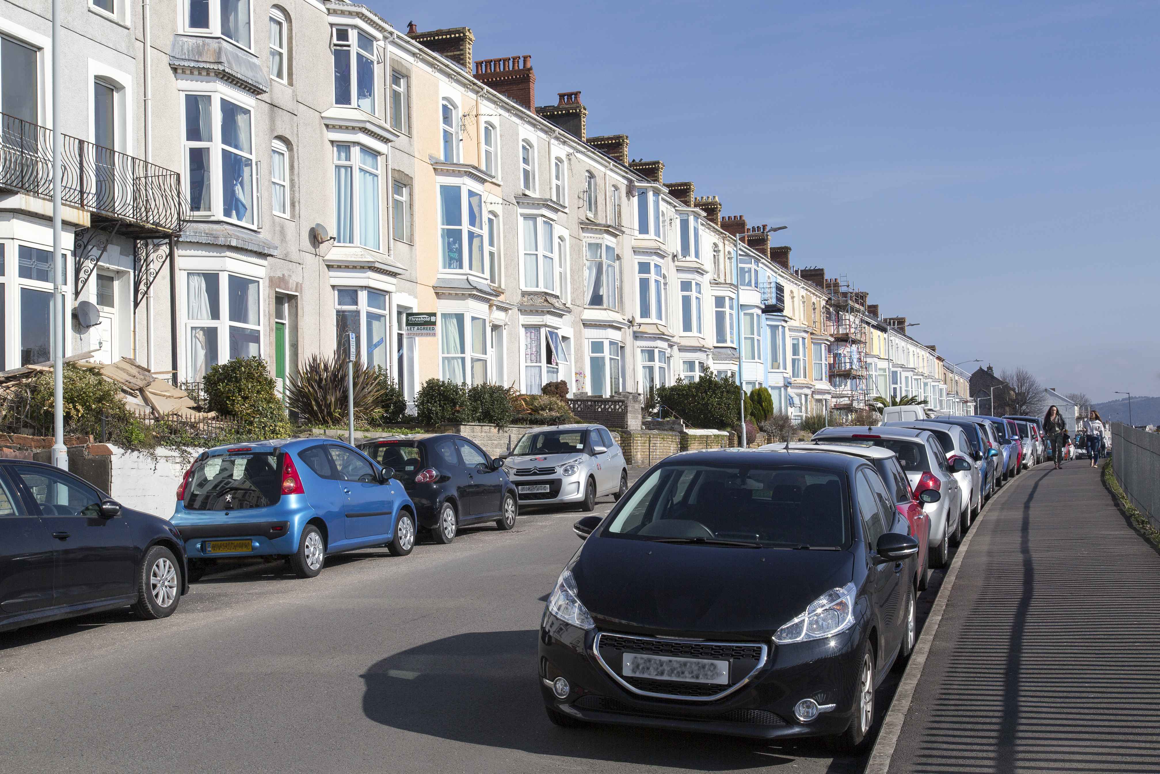 terraced houses in Swansea with cars parked in the street