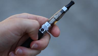 A hand holding an e-cigarette