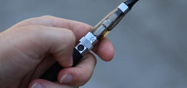 A hand holding an e-cigarette
