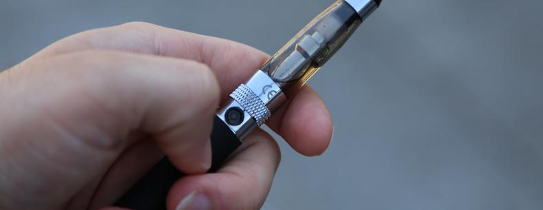 A hand holding an e-cigarette