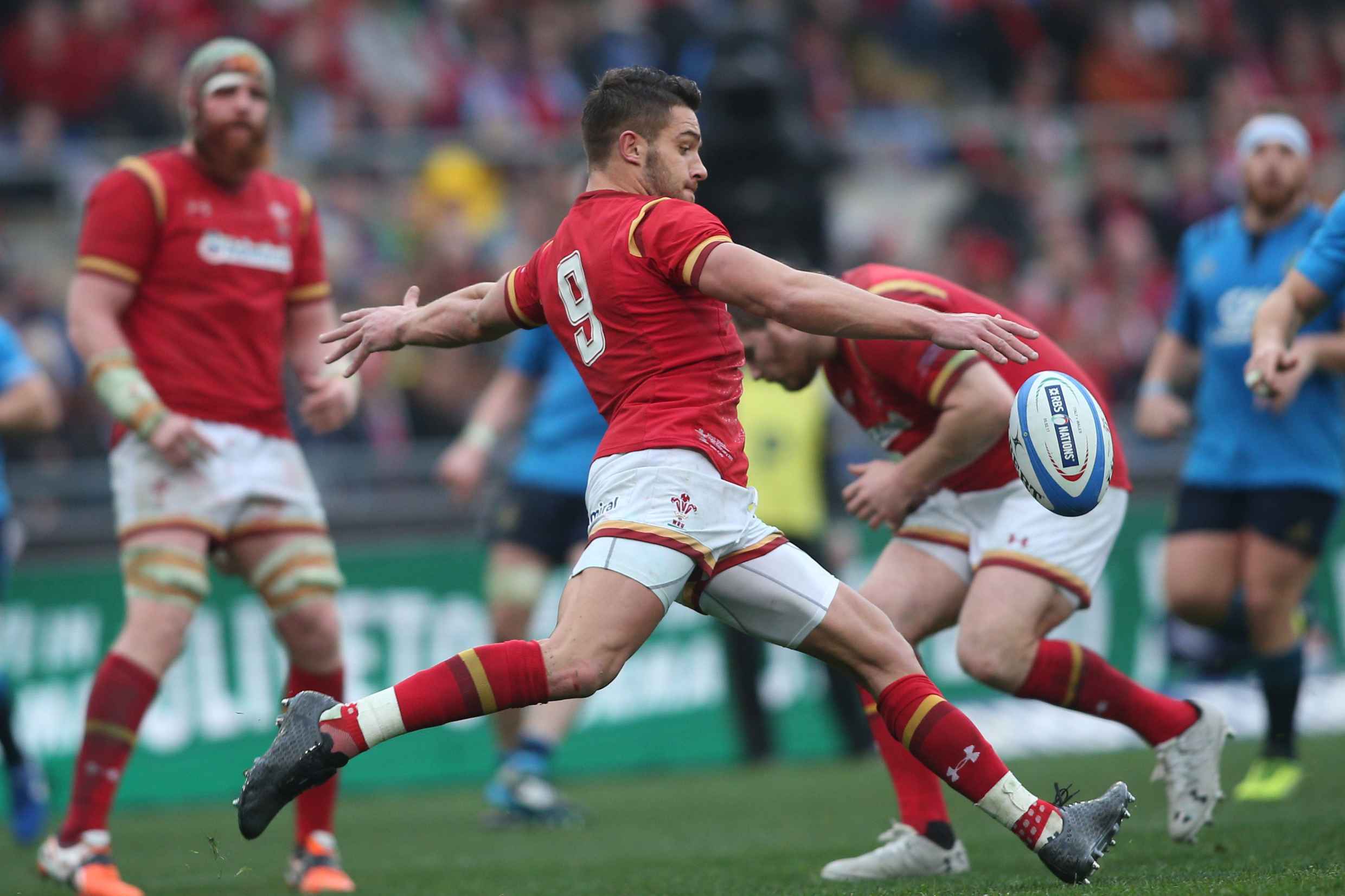 A Welsh rugby player kicks a ball.