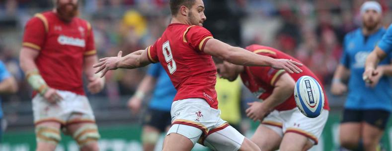 A Welsh rugby player kicks a ball.