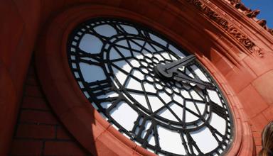 The article’s main image is of the Senedd’s red brick Pierhead clock with blue sky behind on a sunny day