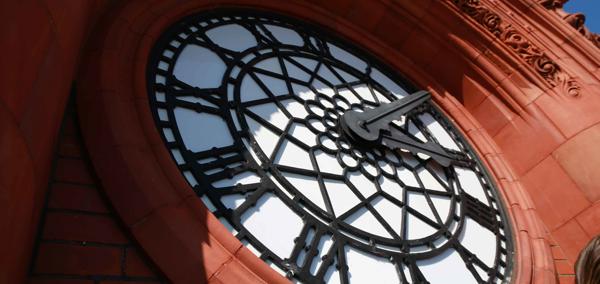 The article’s main image is of the Senedd’s red brick Pierhead clock with blue sky behind on a sunny day