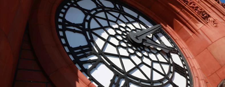 The article’s main image is of the Senedd’s red brick Pierhead clock with blue sky behind on a sunny day