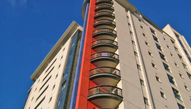 Image of a high-rise block of flats against a blue sky