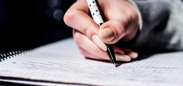 This is a picture of a child writing on paper, implying the undertaking of school work.