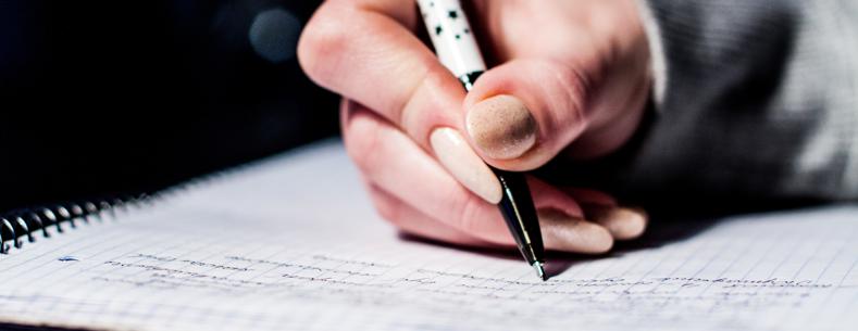 This is a picture of a child writing on paper, implying the undertaking of school work.