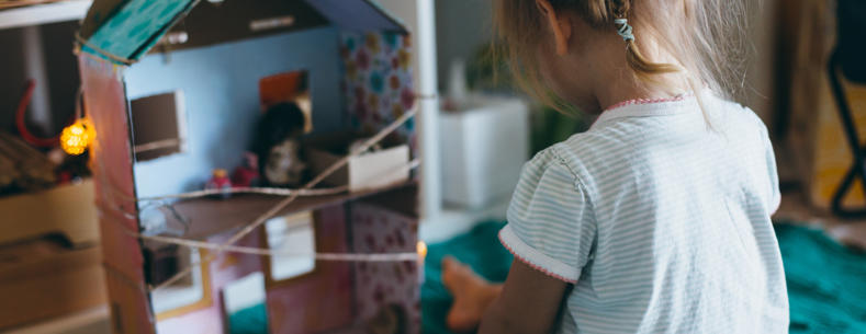 Child playing with a doll’s house.