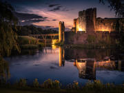 Image of Caerphilly castle lit up in the evening.