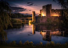 Image of Caerphilly castle lit up in the evening.