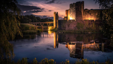 Image of Caerphilly castle lit up in the evening.
