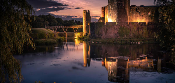 Image of Caerphilly castle lit up in the evening.