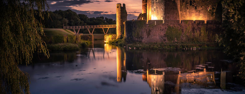 Image of Caerphilly castle lit up in the evening.