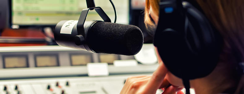 Close up image of a radio presenter talking into a microphone