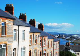 A picture of a row of terraced houses, with a city in the background.