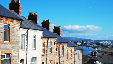 A picture of a row of terraced houses, with a city in the background.