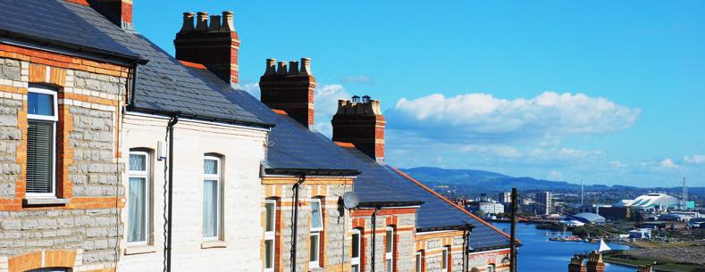 A picture of a row of terraced houses, with a city in the background.