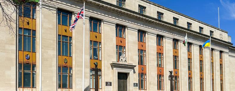 A picture of the outside of the government building in Cathays. The Welsh, UK and Ukraine flags are visible.