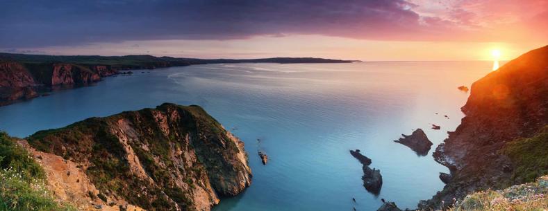 Clifftop above a Pembrokeshire beach looking out to sea at sunset
